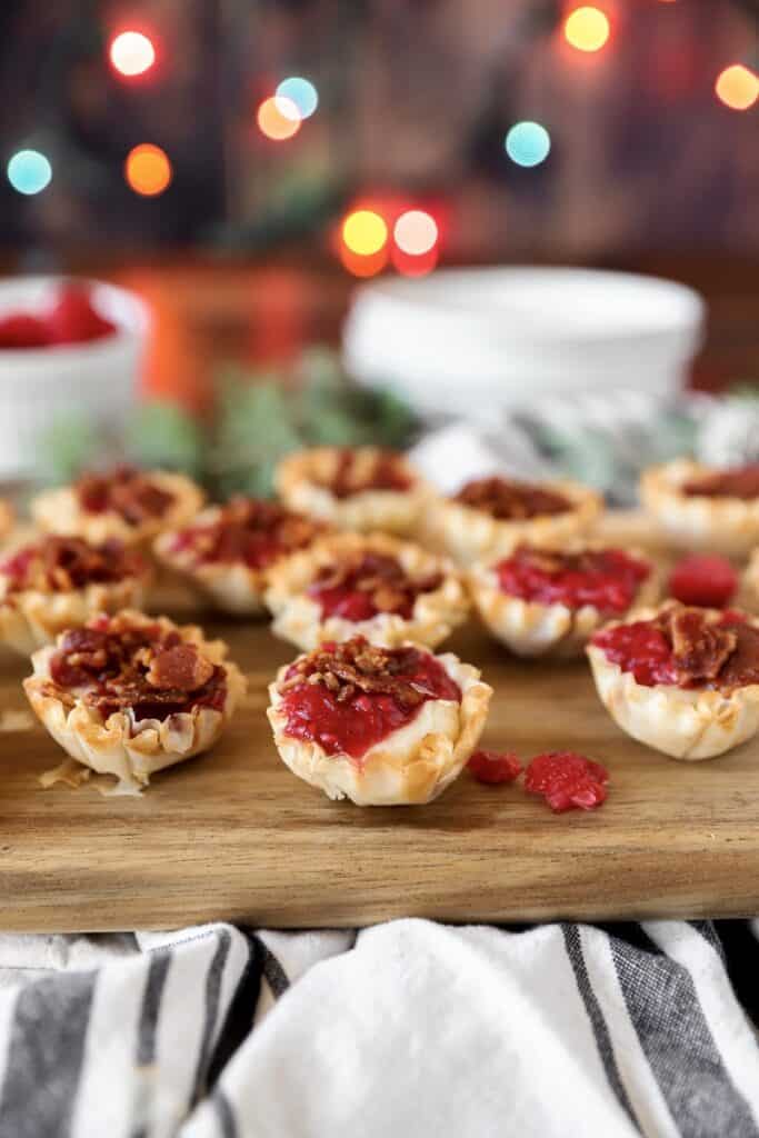 brie and raspberry phyllo bites on a wood cutting board