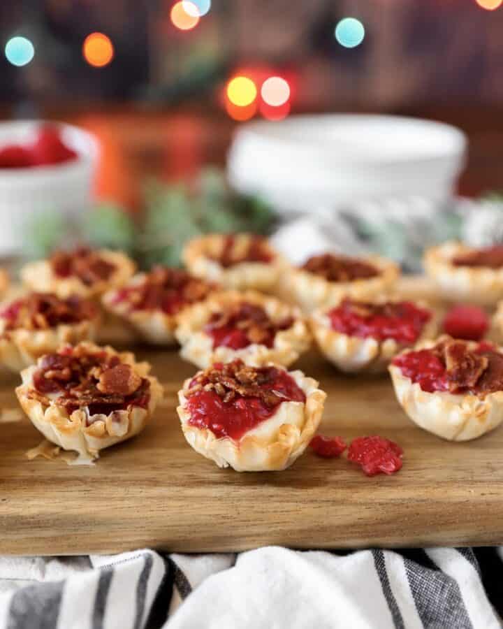 brie and raspberry phyllo bites on a wood cutting board