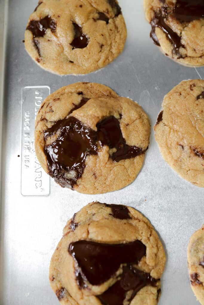 baked chocolate chunk cookies on a silver baking sheet.