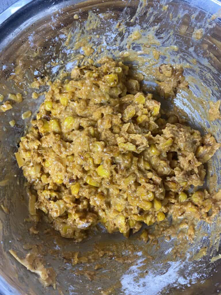 overhead shot of the fritter batter in a silver mixing bowl.