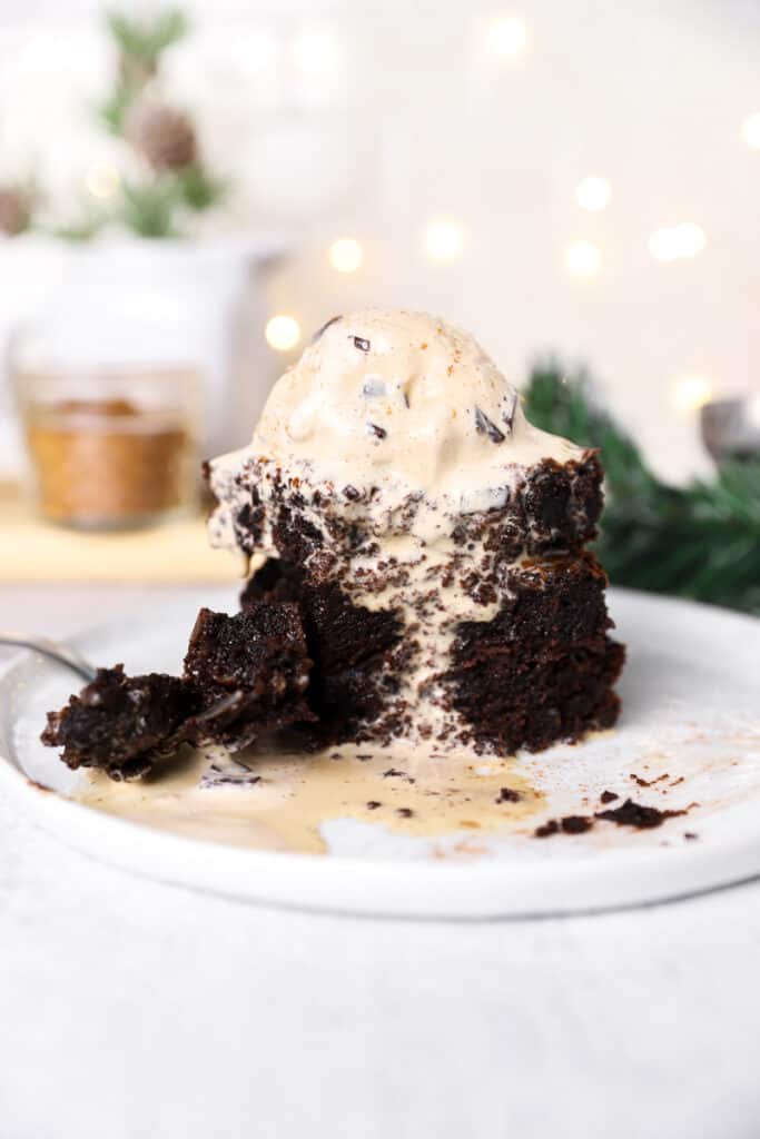 a stack of 3 gingerbread brownies with coffee ice cream on a white plate