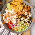chicken burrito bowl with chipotle sauce on a blue striped linen