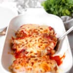roasted red pepper chicken parm in a white casserole dish.