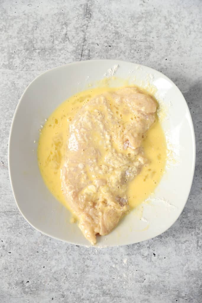 overhead shot of the chicken coated in the egg wash.