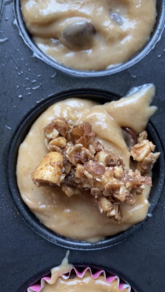 overhead shot of the raw muffin batter topped with the streusel in the muffin tin.