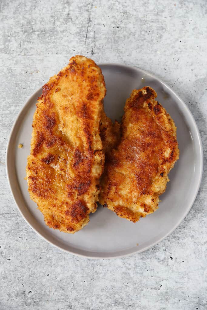 overhead shot of the cooked butterflied chicken on a round grey plate.