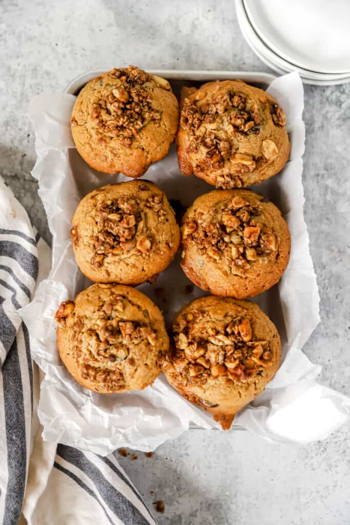 overhead shot of 6 peanut butter muffins in a tray lined with parchment paper.