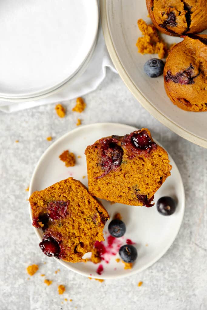 one of the muffins sliced open on a white round plate