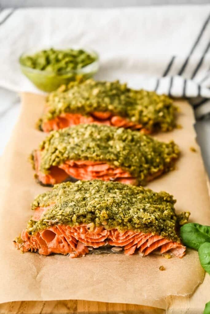 3 pesto topped salmon on brown paper.