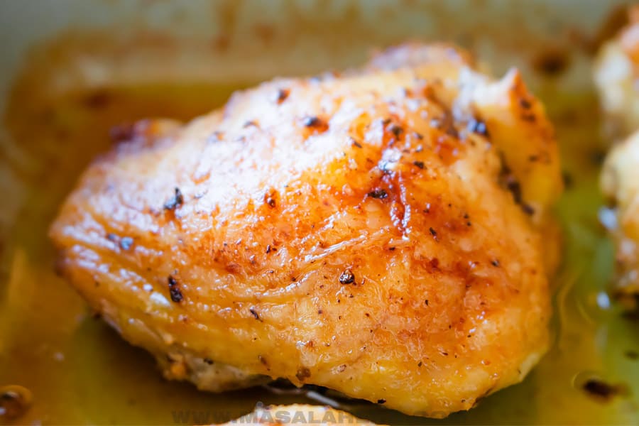 one oven roasted chicken thigh in a baking dish.