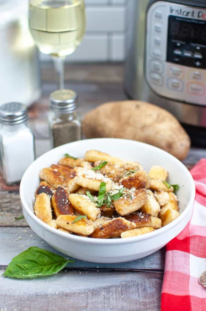 a bowl of the gnocchi with salt and pepper shakers in the back.