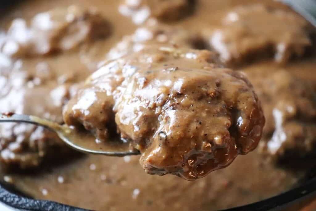 hamburger steak in brown gravy on a spoon