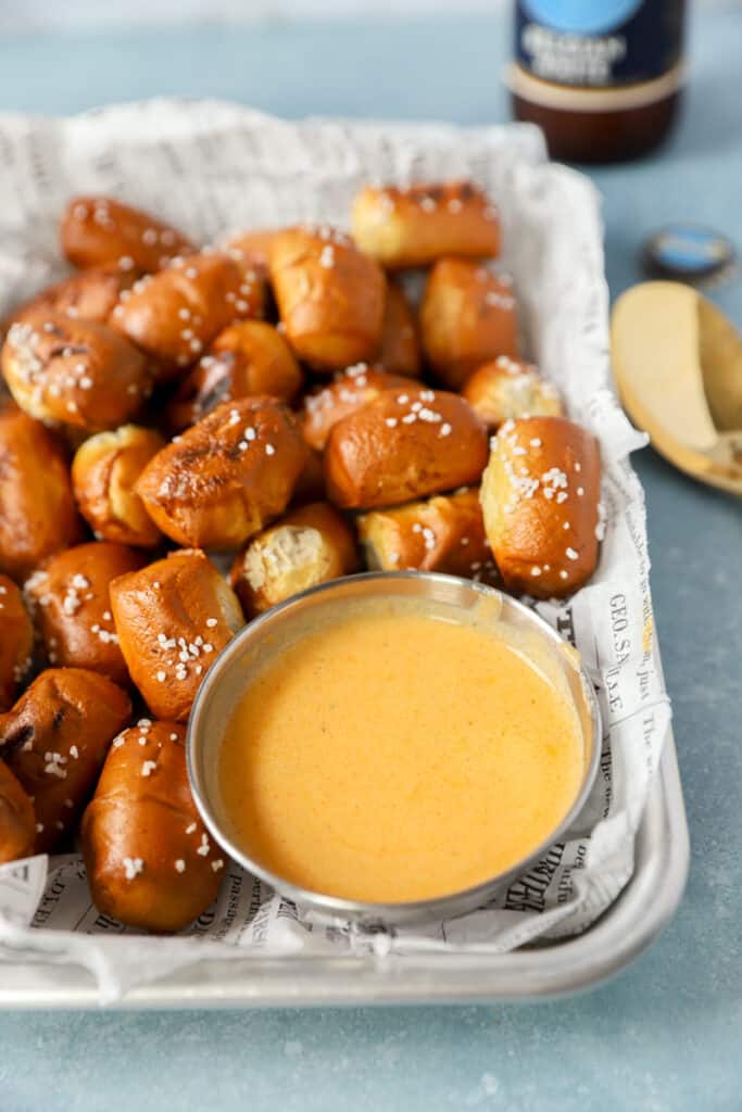 the sauce in a silver dish surrounded by pretzel bites.