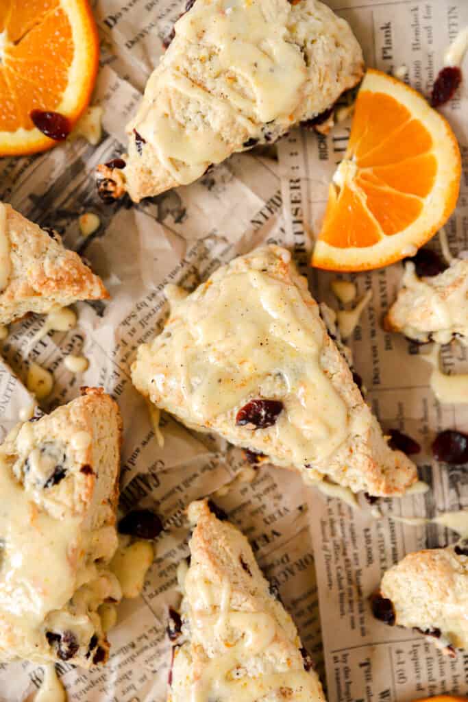 overhead shot of the orange cranberry scones on brown newsprint paper