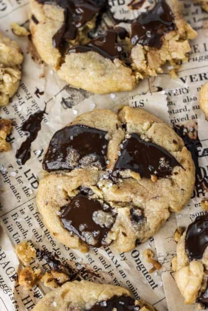 overhead shot of chocolate chunk cookies on brown newsprint paper.