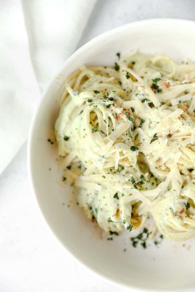 overhead shot of the pasta swirls in a white round bowl, with a white linen off to the upper left.