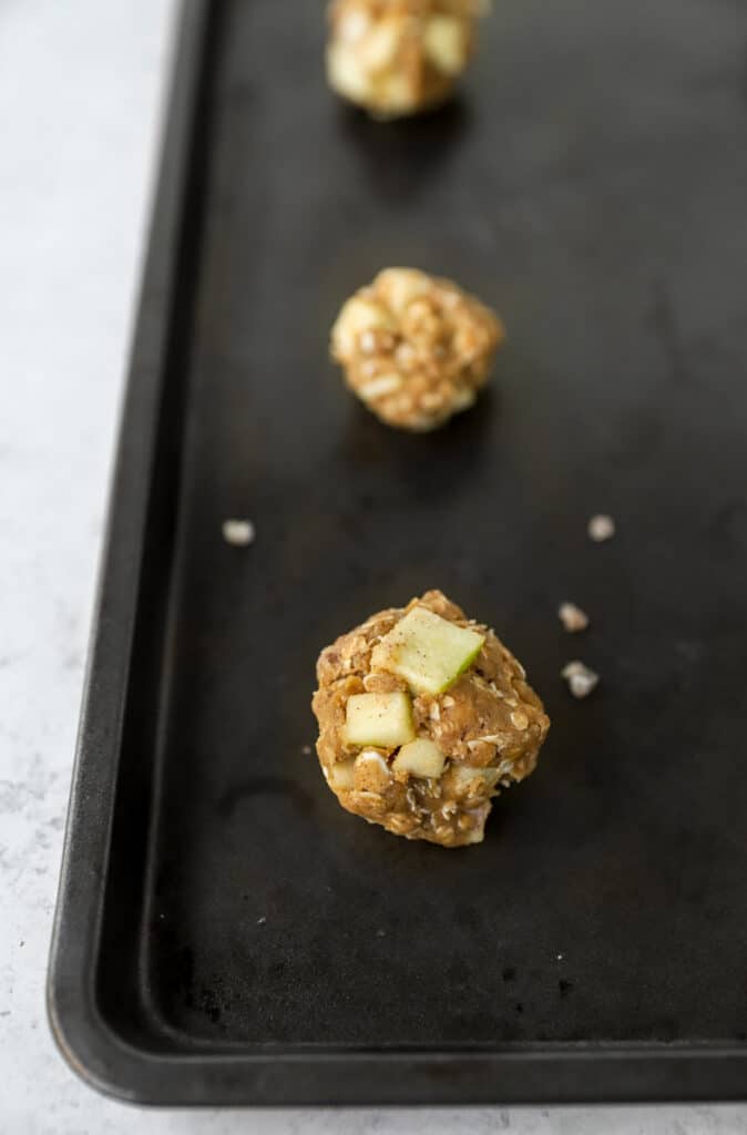 the unbaked cookie dough on a dark nonstick cookie sheet.