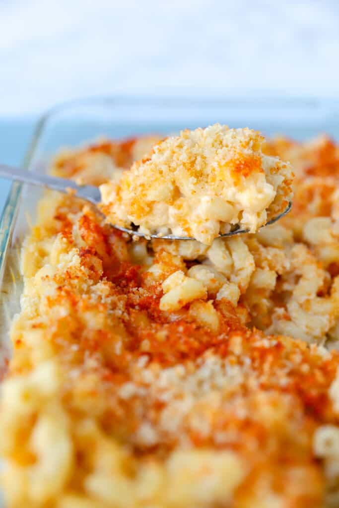 a spoon scooping the mac and cheese from the casserole dish