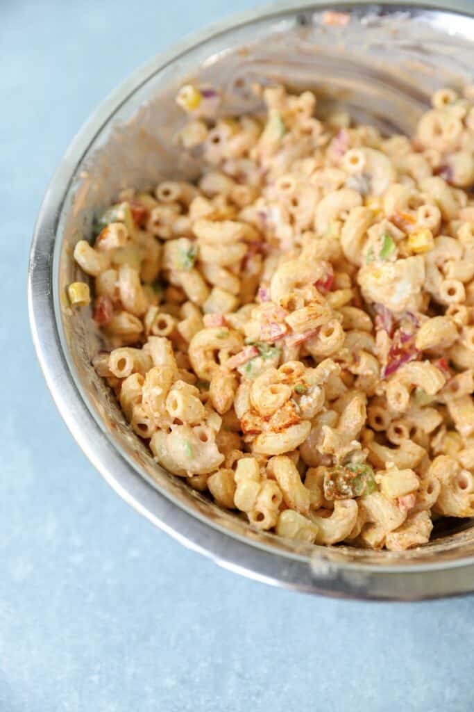 angled photo of the pasta salad in a silver mixing bowl.