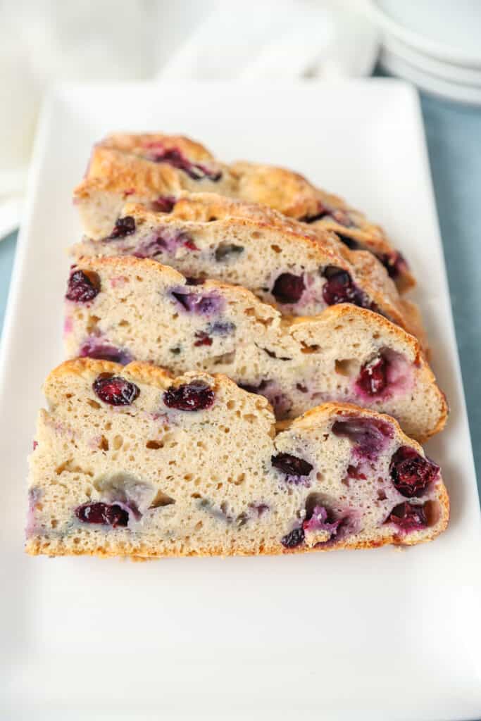 slices of the blueberry soda bread on a rectangle white plate.