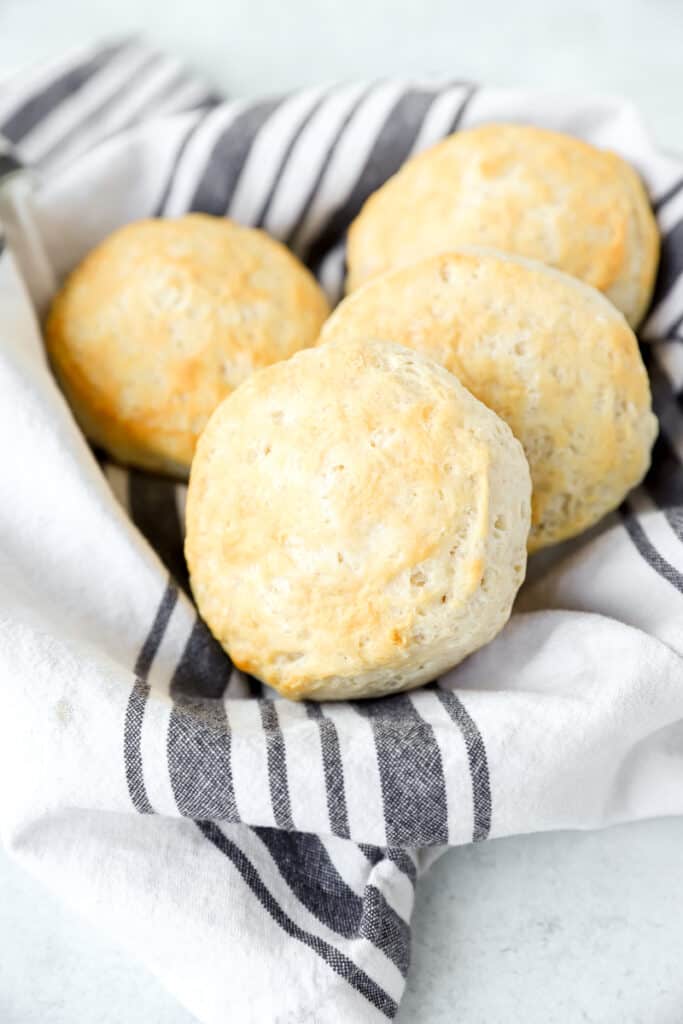 4 baked biscuits in a blue and ivory linen napkin.