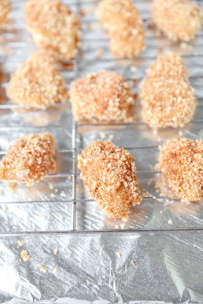 the unbaked seasoned and breaded chicken nuggets on the baking rack.