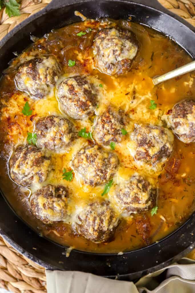 overhead photo of the French onion meatballs in a cast iron skillet.