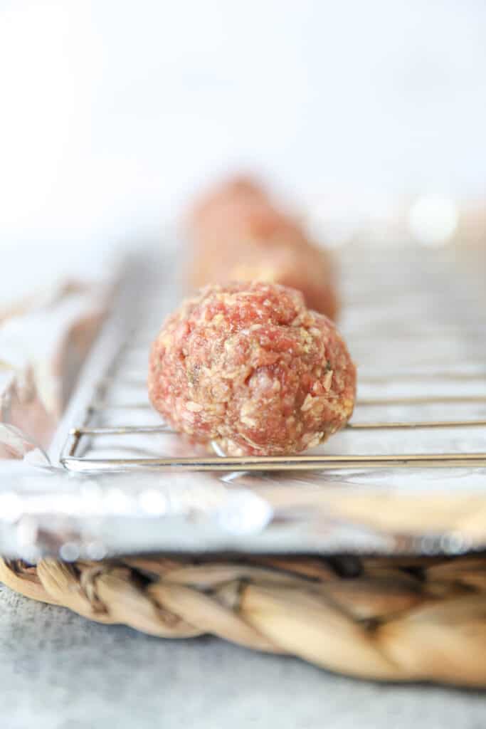 the raw unbaked meatballs on the baking sheet.