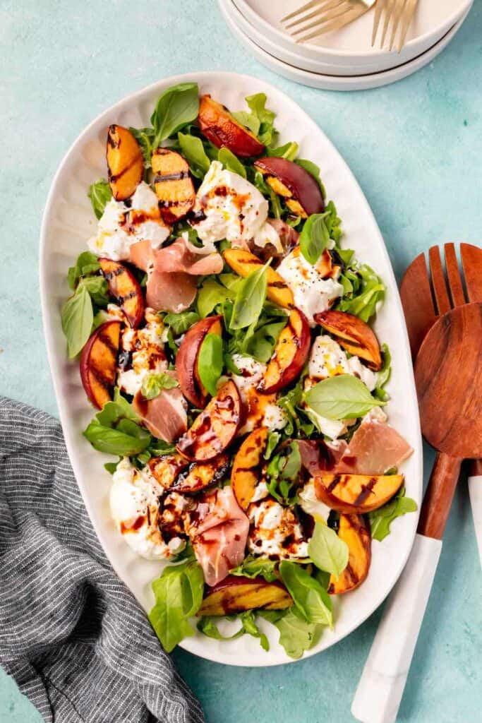 overhead photo of the grilled peach and burrata salad drizzled with balsamic