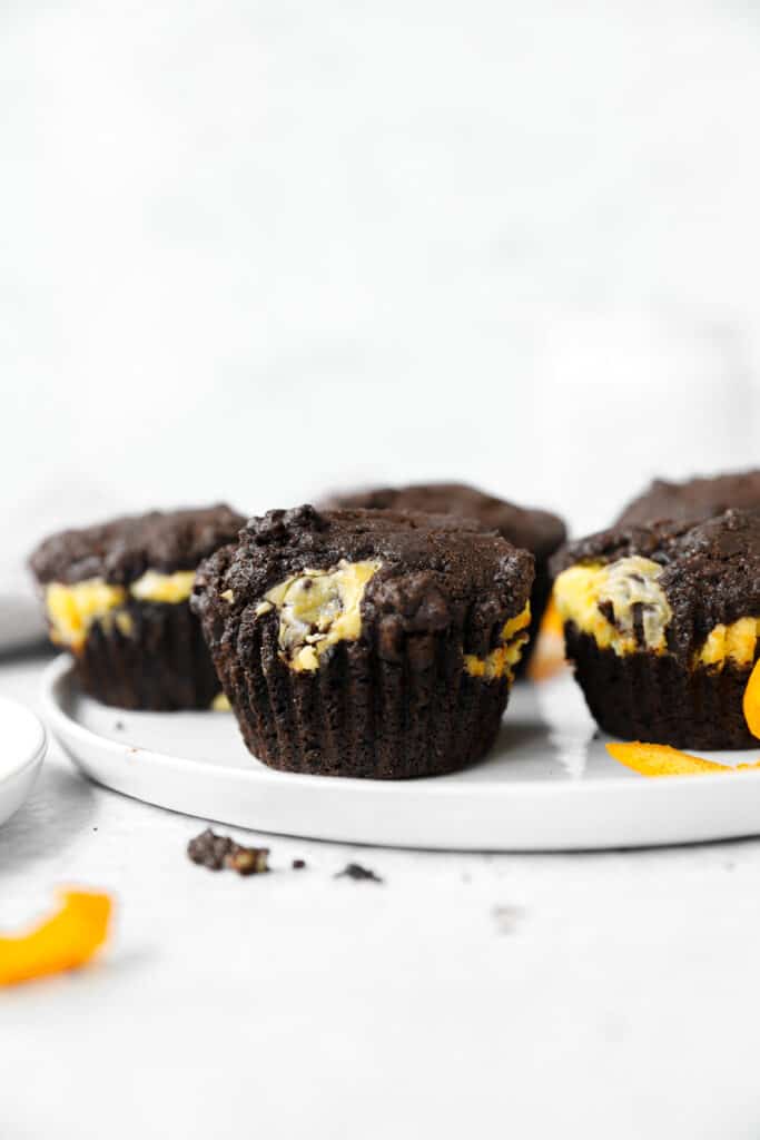 chocolate orange muffins baked on a round white plate.