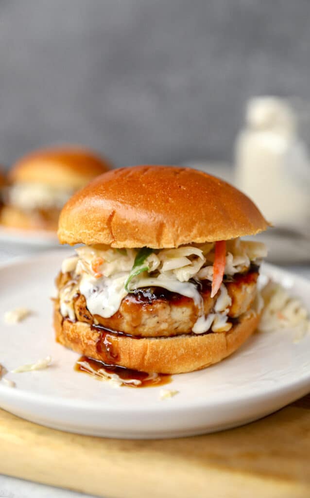 chicken teriyaki burger on a round white plate