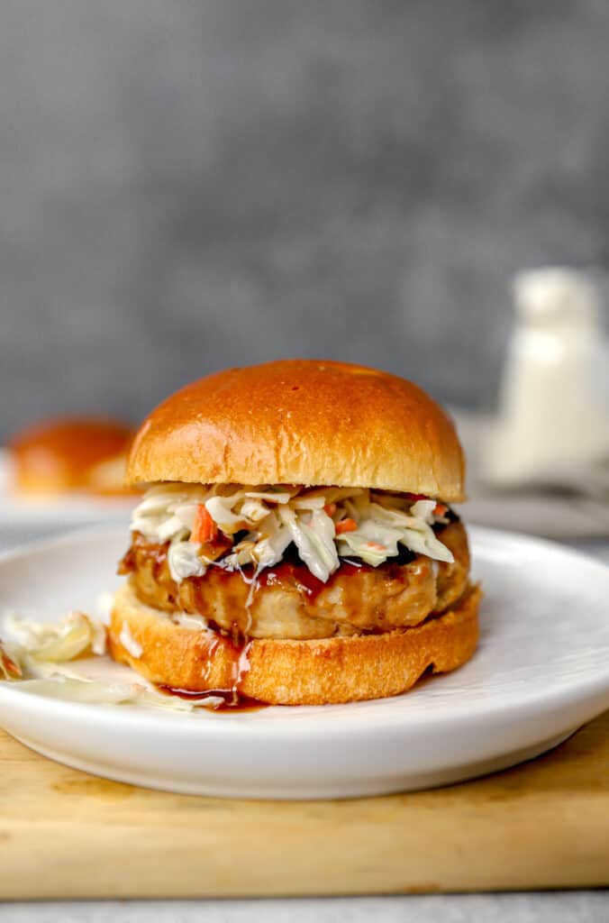 chicken teriyaki burger on a round white plate