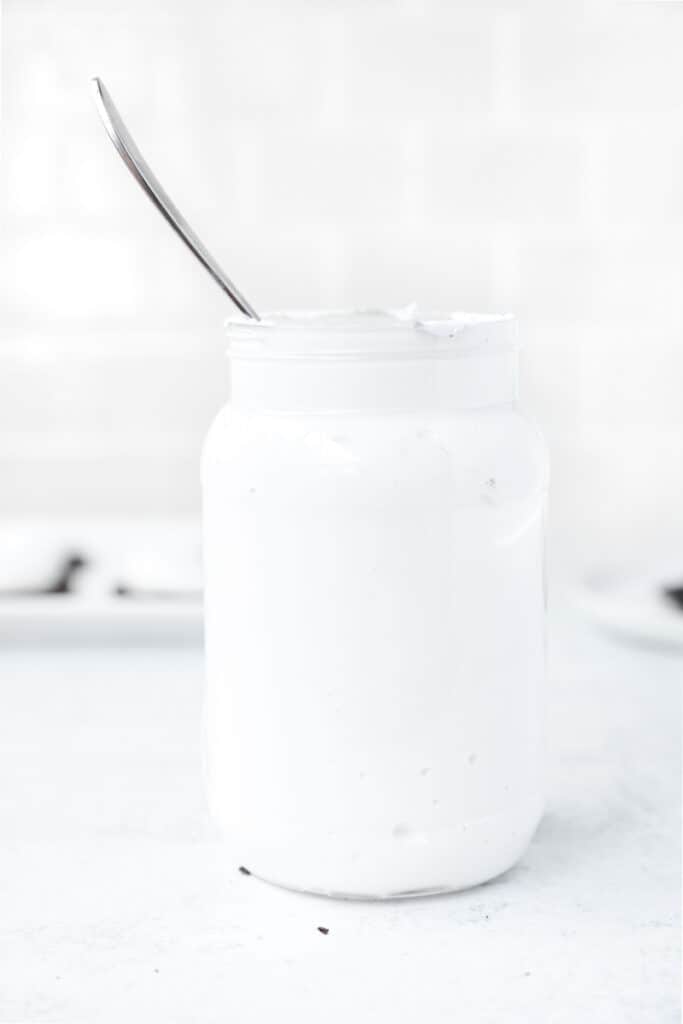 the jar of marshmallow fluff, label removed, with a silver spoon sticking out the top of the jar.