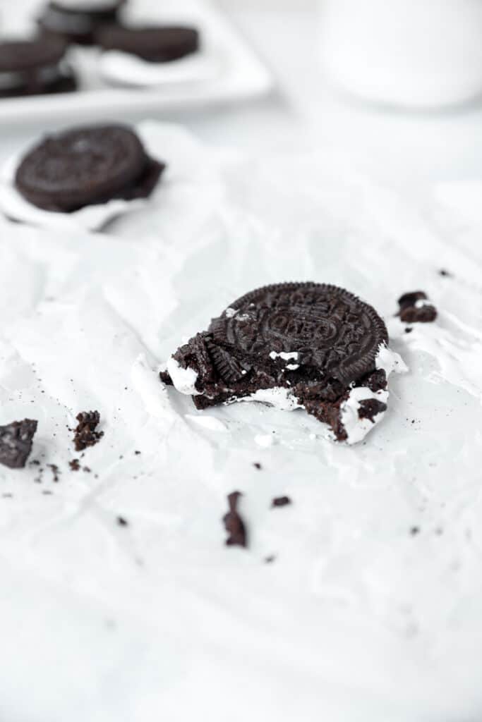 one Oreo s'more on parchment paper with cookie crumbs scattered around.