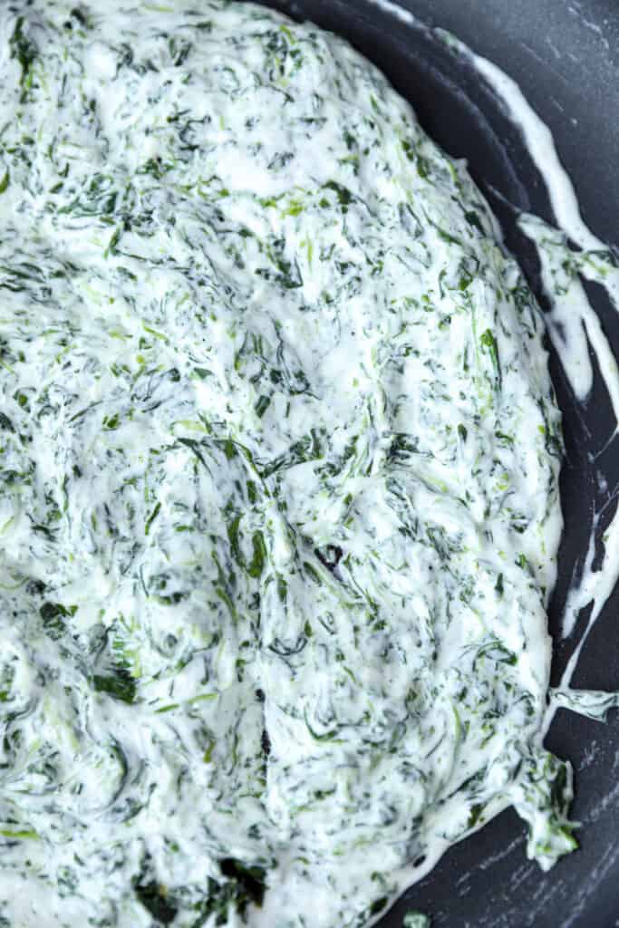 overhead photo of the creamy spinach dip filling in a non-stick pan.