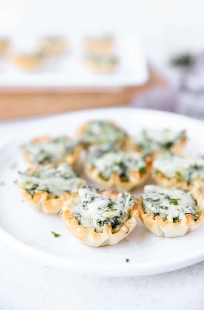 spinach dip bites on a round white plate.