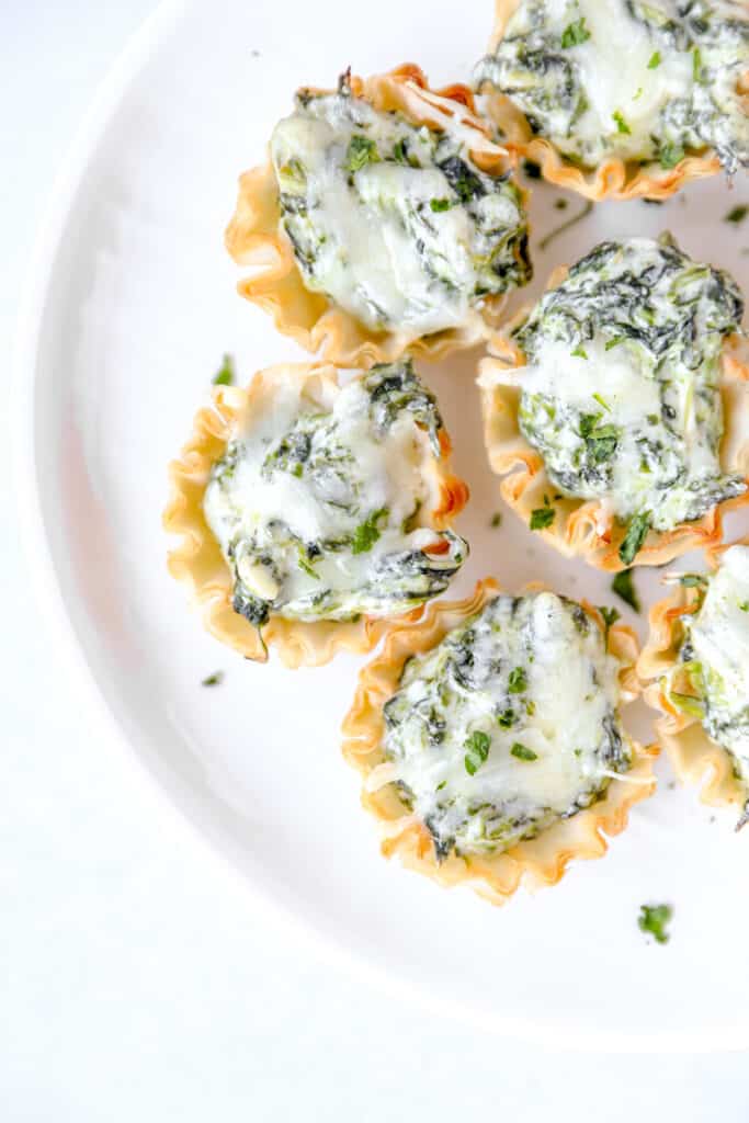 overhead photo of the spinach dip bites on a round white plate.