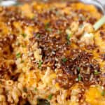 buffalo chicken mac and cheese topped with crushed pretzels in a glass casserole dish