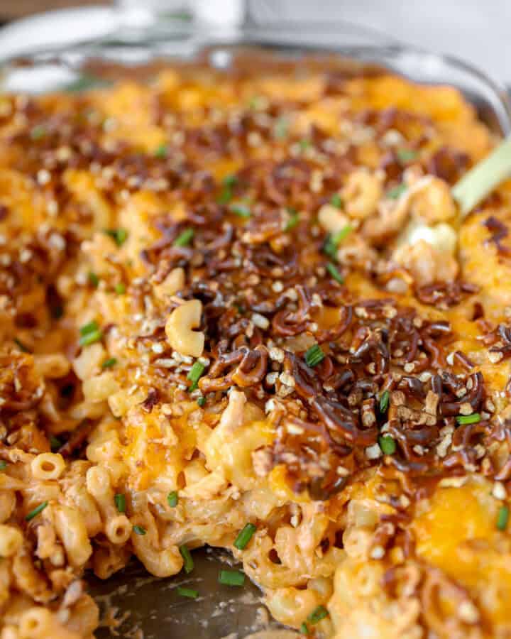 buffalo chicken mac and cheese topped with crushed pretzels in a glass casserole dish