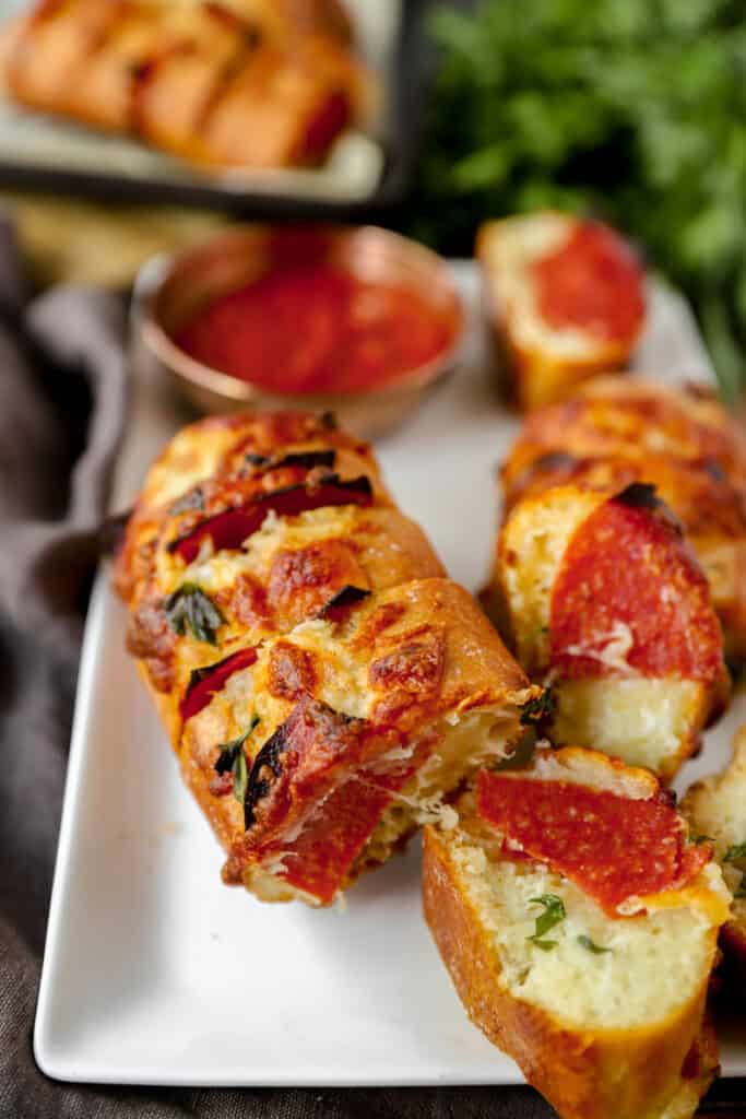 pepperoni stuffed garlic bread on a white platter