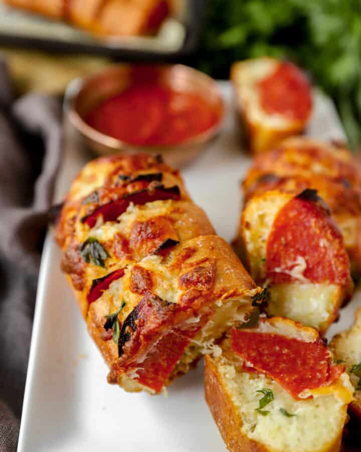 pepperoni stuffed garlic bread on a white platter
