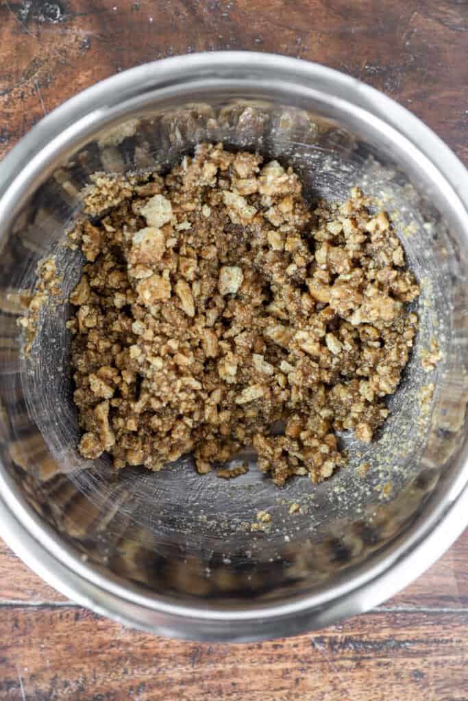 overhead photo of the graham cracker crust mixed in a stainless steel bowl.