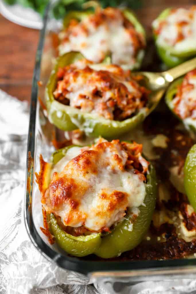 Baked stuffed peppers in a clear casserole baking dish.