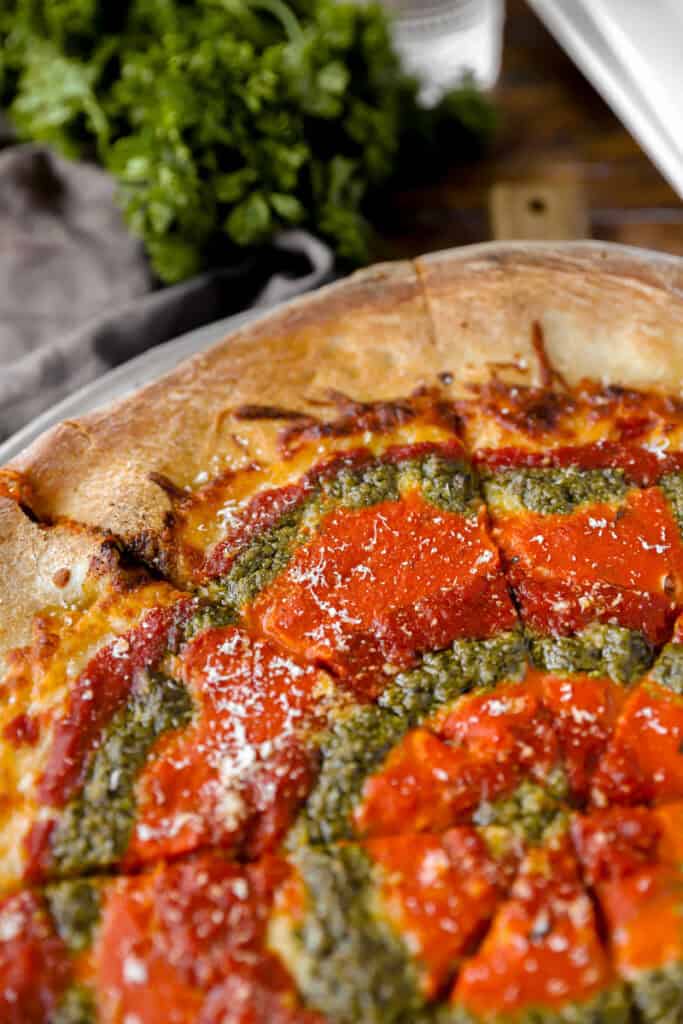 mvp pizza baked swirled with marinara, vodka, and pesto sauces.