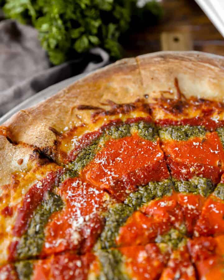 mvp pizza baked swirled with marinara, vodka, and pesto sauces.