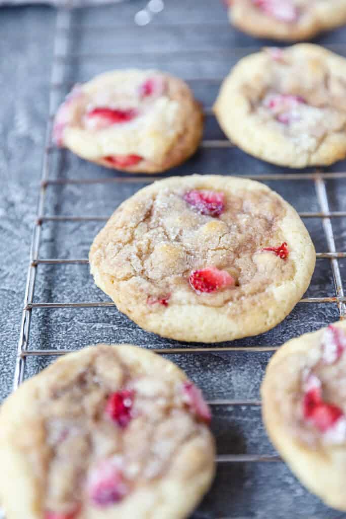 strawberry and cream cookies on a cooling rack on a grey surface.