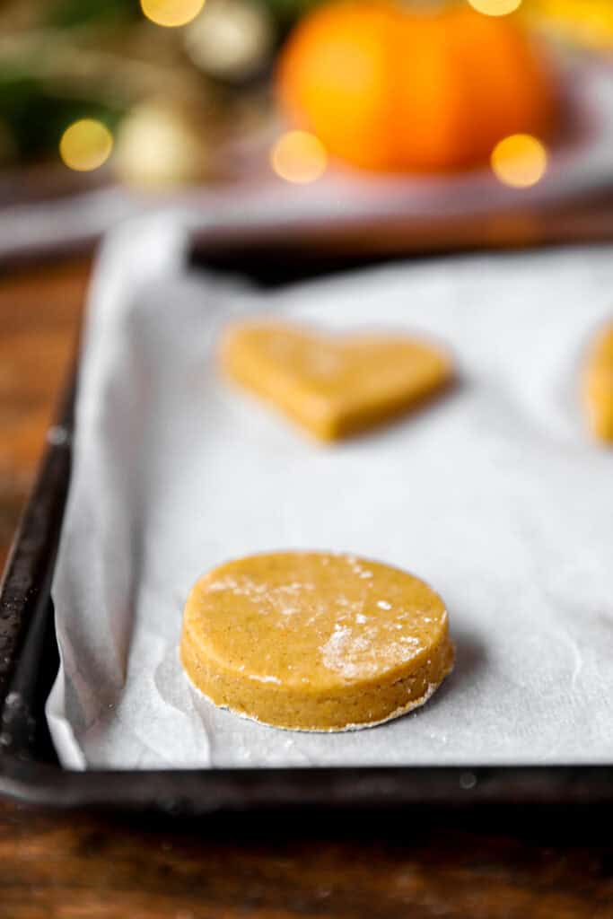 the unbaked cookie dough shapes on the parchment paper lined baking sheet.