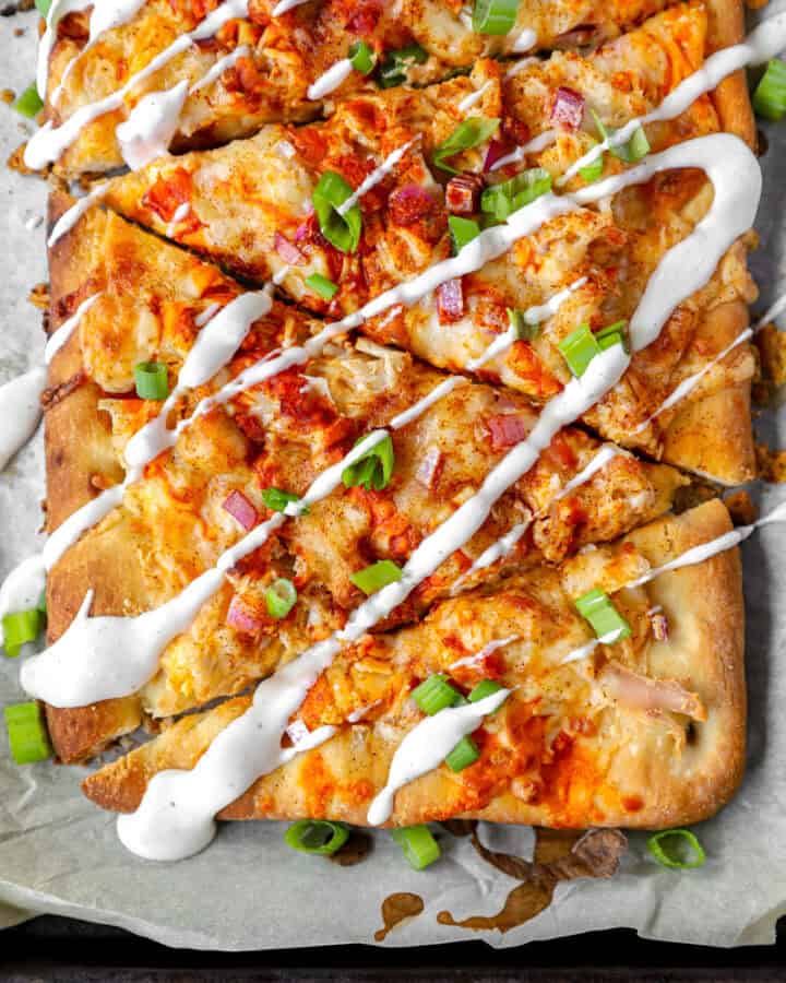 overhead photo of sliced Buffalo chicken flatbread with ranch drizzle