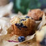 banana blueberry oat muffins baked on brown parchment paper.