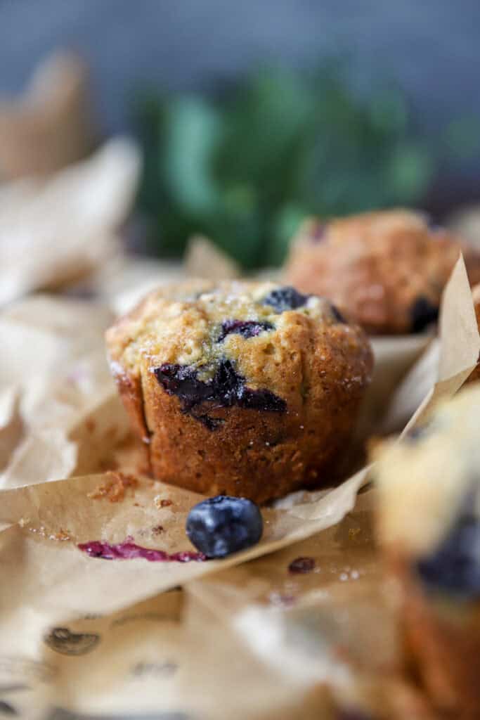 banana blueberry oat muffins baked on brown parchment paper.